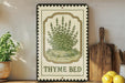 A framed illustration of a thyme plant is displayed on a shelf, accompanied by a wooden cutting board, a potted plant, and some lemons.
