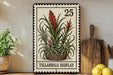 A metal sign with a plant illustration and the number 25, placed on a wooden surface next to a wooden cutting board and some potted plants.