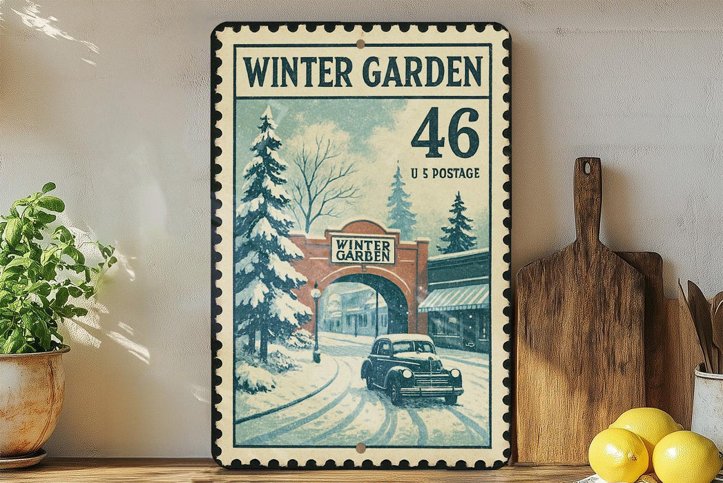 A vintage-style metal stamp depicting a snowy winter scene with a car driving through a bridge, surrounded by pine trees and a building.
