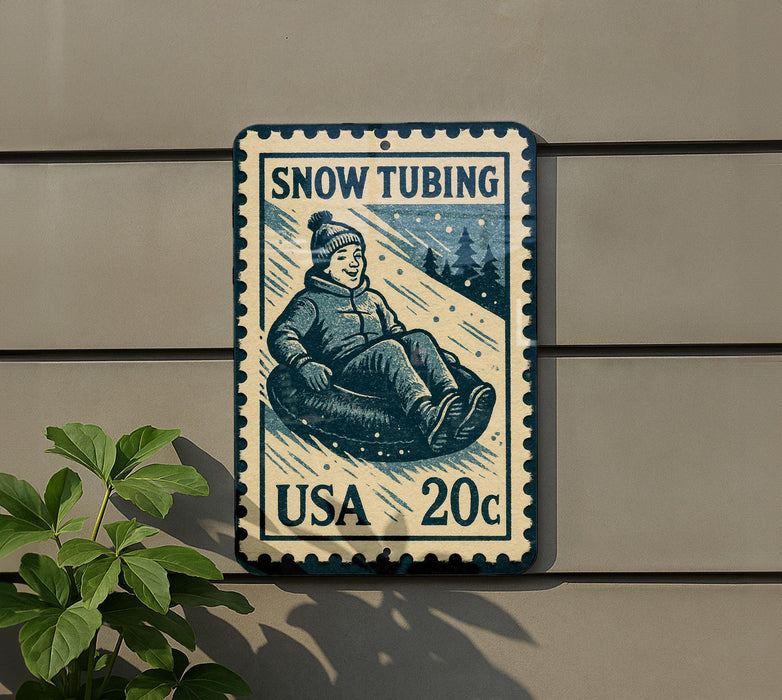 A vintage-style snow tubing postage stamp is displayed on a wall, featuring a smiling child riding a sled down a snowy hill.