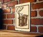 a brick wall with a wooden table in the foreground. There is a sign with an illustration of a metal container or tool on the wall.