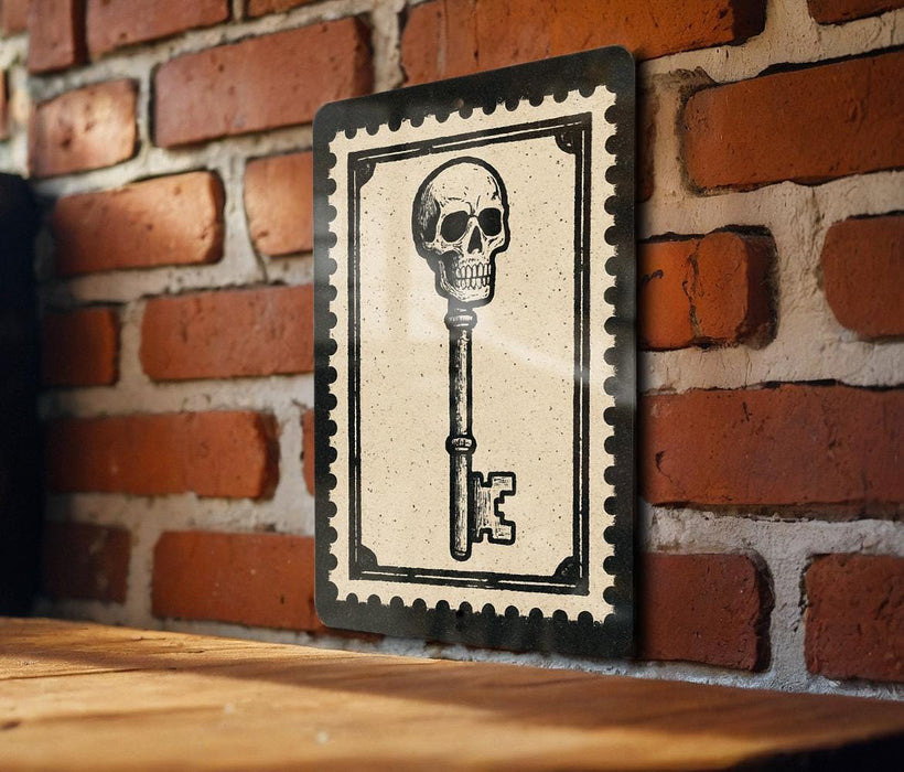 A framed image of a skull with a key is displayed on a brick wall.