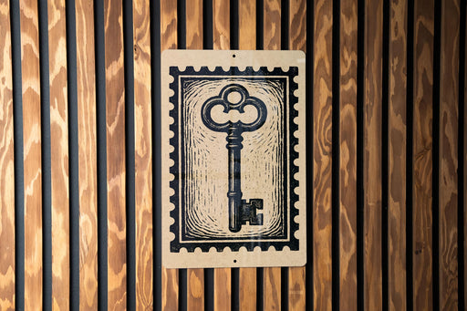 A black and white key-shaped stamp is displayed on a wooden wall.
