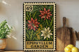 A metal sign with a floral design, featuring a large red flower and two smaller white flowers, is displayed on a shelf next to a wooden cutting board and a potted plant.