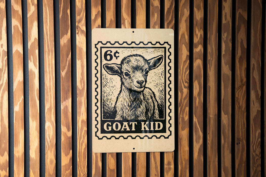 A wooden wall with a black and white stamp-like sign featuring a goat's face and the text "GOAT KID" printed on it.