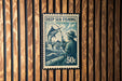 A postage stamp featuring a man fishing in the ocean, with a large fish in the background.