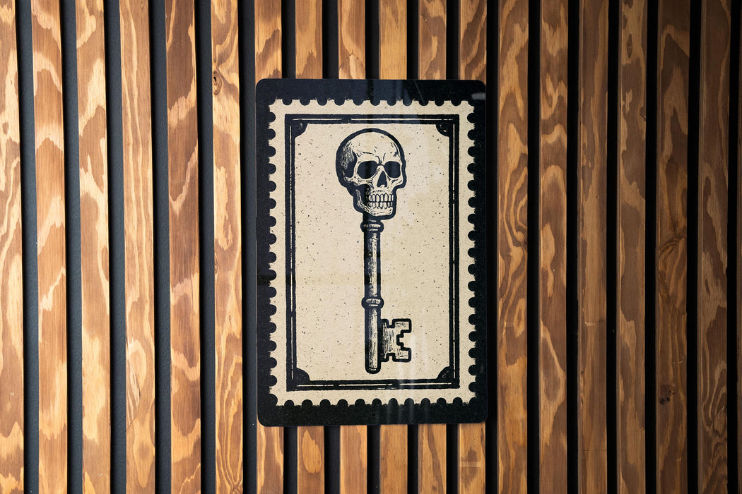 a key with a skull on it, which is mounted on a wooden wall.