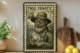 a vintage-style metal sign with a bearded man wearing a hat and glasses, holding a frog, surrounded by other frog illustrations. The sign is placed on a wooden surface, with a potted plant, a cutting board, and some lemons nearby.