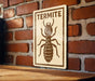 A sign with the word "TERMITE" on it, depicting a large insect, is mounted on a brick wall.