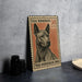 A metal stamp featuring a close-up of a Thai Ridgeback dog, with the text "THAI RIDGEBACK 50 SATANG" printed on it.