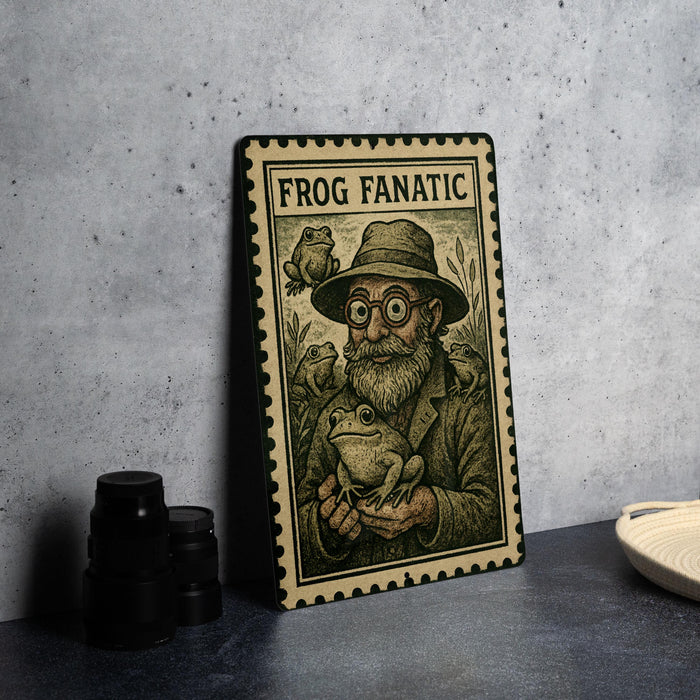 a framed illustration of a man with a beard and glasses, holding a frog, with the text "FROG FANATIC" on the frame.