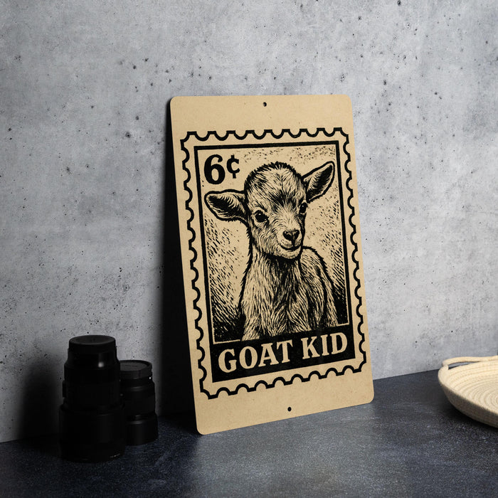 A wooden sign featuring a black and white illustration of a young goat, with the text "GOAT KID" printed on it, placed on a gray countertop next to some black camera lenses.