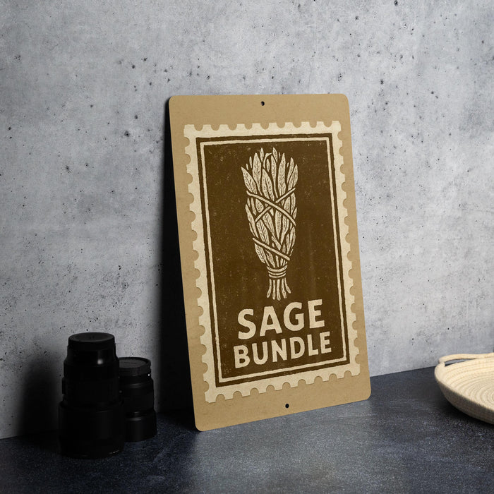 a brown sign with the text "SAGE BUNDLE" on it, placed on a gray countertop next to some black camera lenses.