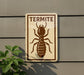a sign with a picture of a termite on it, mounted on a wall.