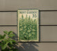 A metal sign with a mint plant illustration is mounted on a wall, with a plant visible to the left.