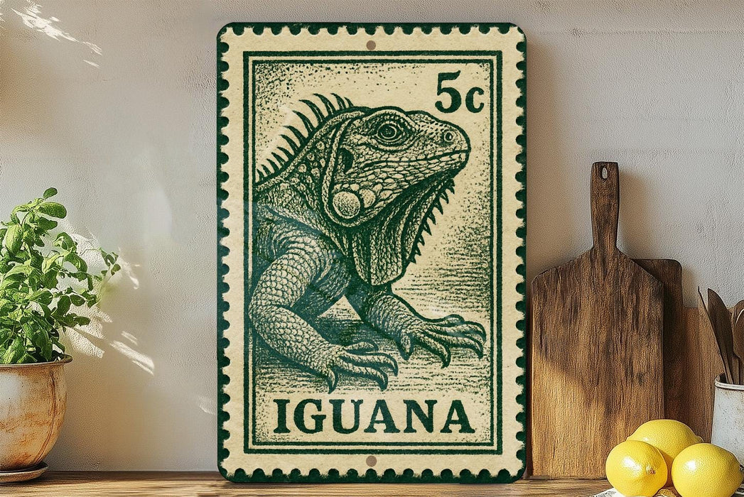 A green and white postage stamp featuring an illustration of an iguana, with the word "Iguana" printed on it. The stamp is placed on a shelf next to a wooden cutting board and some potted plants.