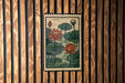 A framed illustration of lotus flowers is displayed on a wooden wall.