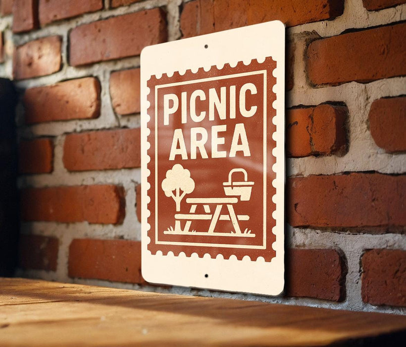 A sign indicating a picnic area is mounted on a brick wall.