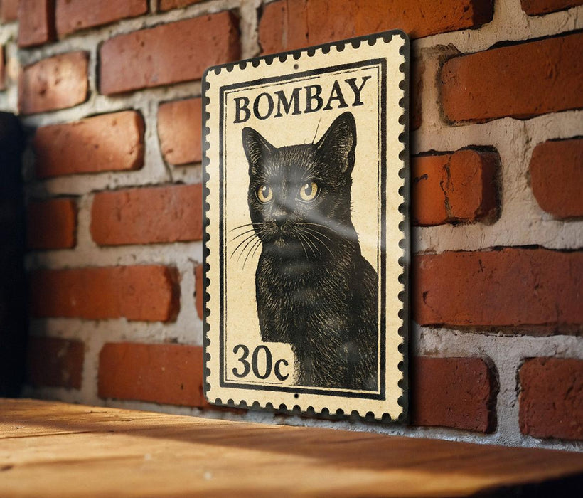 A vintage-style metal stamp featuring a black cat on a brick wall.
