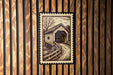 A wooden wall with a framed image of a covered bridge in the center.