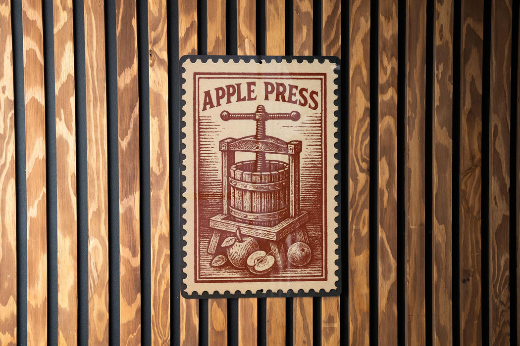 a wooden wall with a vintage-style stamp or sign that reads "APPLE PRESS" and depicts a wooden press machine with apples.