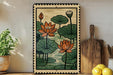 a framed print of a floral design with lotus flowers and lily pads, displayed on a shelf next to a wooden cutting board and some lemons.