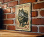 A metal sign featuring a German Spitz dog, with the number 40 below it, is mounted on a brick wall.