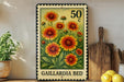 A metal stamp with a floral design featuring yellow and orange flowers, placed on a wooden surface next to a wooden cutting board and some lemons.