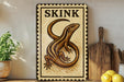 a wooden cutting board with a decorative sign featuring a lizard, placed on a wooden surface next to a potted plant and some lemons.