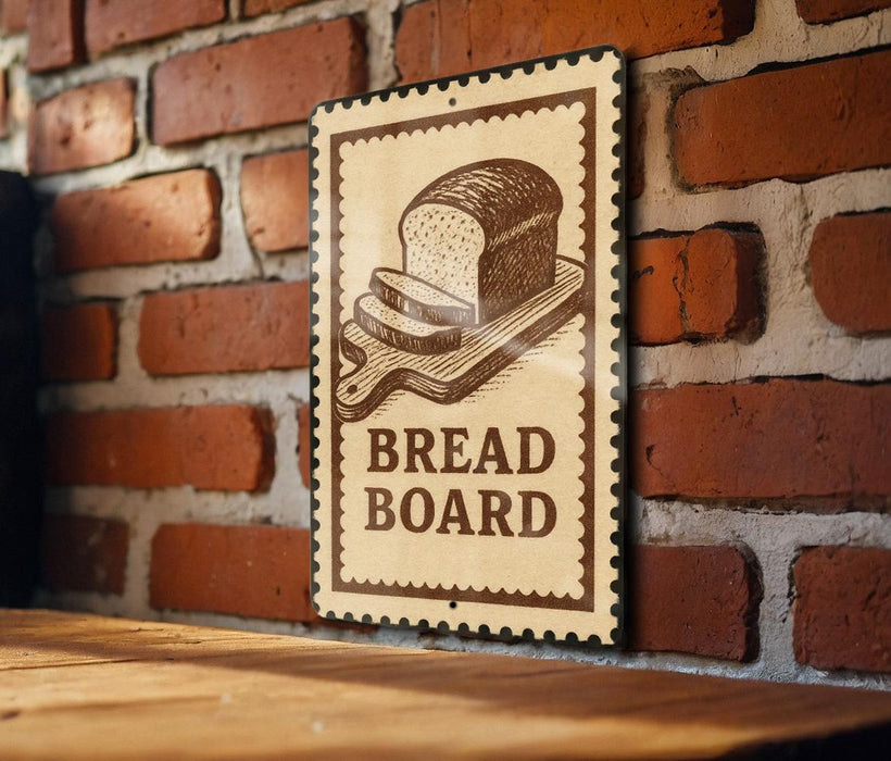 A sign with the word "BREAD BOARD" is displayed on a brick wall, with a wooden table below it.