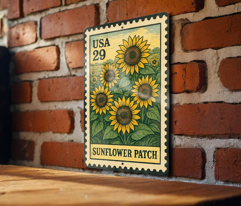 A vintage-style metal stamp depicting a field of sunflowers, mounted on a brick wall.