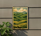 a framed painting of a countryside landscape with rolling hills and a cloudy sky, hanging on a wall next to a plant.