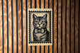 A black and white illustration of a cat wearing a bow tie is displayed on a wooden wall.