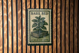A metal sign with a plant illustration and text is mounted on a wooden wall.