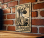 A wooden sign with a black and white illustration of a dog, mounted on a brick wall.
