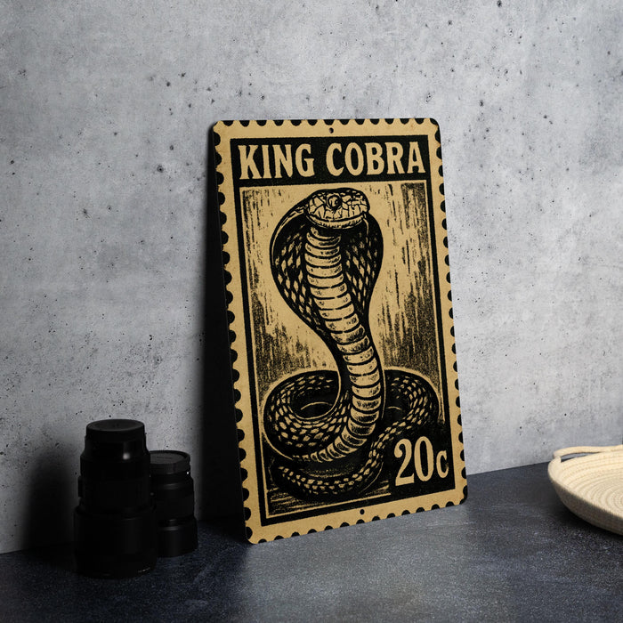 A metal sign featuring a black and gold illustration of a cobra, with the text "KING COBRA" and "20c" printed on it.