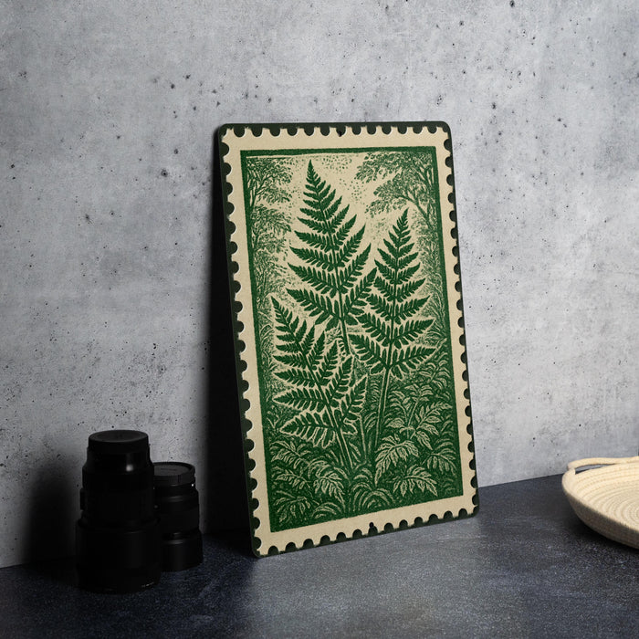 a framed artwork of a fern plant on a wall, with a stack of black camera lenses placed next to it.