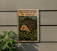 A sign with the text "HEDGEHOG IN HEDGE" and an illustration of a hedgehog is mounted on a wall.