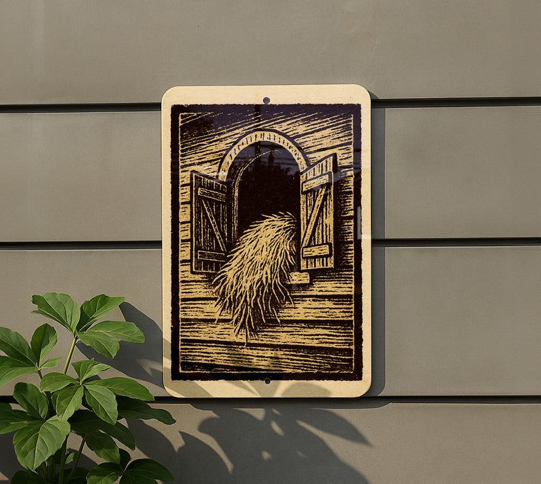 a sign with an illustration of a barn door and a pile of hay, mounted on a wall.