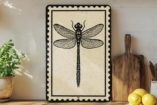 a framed picture of a dragonfly on a shelf, surrounded by various kitchen utensils and a potted plant.
