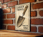 A vintage-style metal sign with a trowel illustration is mounted on a brick wall.