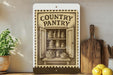 a vintage-style illustration of a pantry door with various food items displayed inside, such as jars, baskets, and bottles. The pantry door is framed by a decorative border, and the text "COUNTRY PANTRY" is prominently displayed above the illustration. The pantry is set against a backdrop of a wooden shelf, and there are some potted plants and kitchen utensils visible in the background.