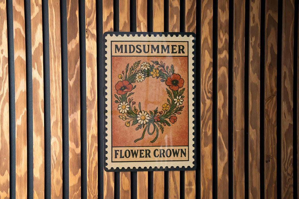 A vintage-style metal sign with the text "MIDSUMMER FLOWER CROWN" displayed on it, mounted on a wooden wall.