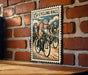 A vintage-style poster of a cycling race, featuring three cyclists racing on a road with a brick wall in the background.