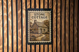 A sign for "Stone Cottage" is displayed on a wooden wall, featuring an illustration of a cottage surrounded by trees and a path leading up to it.