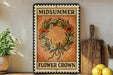 A vintage-style metal sign with the text "MIDSUMMER FLOWER CROWN" displayed on it, surrounded by a wreath of flowers and a wooden cutting board.