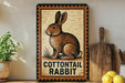 A framed illustration of a cottontail rabbit is displayed on a shelf, accompanied by a wooden cutting board and a potted plant.