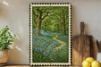 A framed painting depicting a lush forest with a winding path through the center, surrounded by blue flowers. The painting is set against a white wall, with a wooden cutting board and a potted plant to the left.