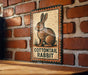 A sign featuring a cartoon image of a rabbit, mounted on a brick wall.