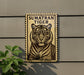 a tiger, which is a large wild cat, depicted in a stamp-like frame.
